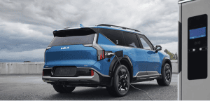blue kia ev9 plugged into charger